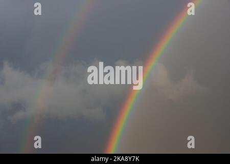 Parte di un arcobaleno su un cielo nuvoloso, una tempesta, una luce Foto Stock