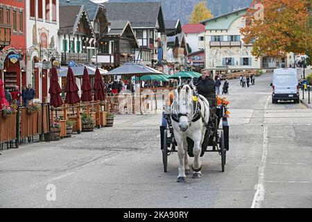 Una carrozza trainata da cavalli trasporta turisti e visitatori per le strade della piccola città bavarese di Leavenworth, Washington. Foto Stock