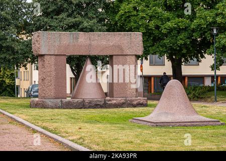 Finlandia, Kotka - 18 luglio 2022: Statue geometriche in marmo poste su prato verde al di fuori della biblioteca cty. Fogliame verde sopra. Foto Stock