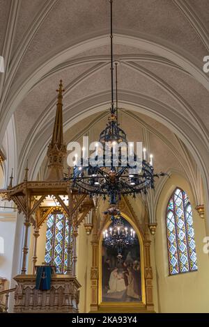 Finlandia, Kotka - 18 luglio 2022: Chiesa Parrocchiale di Kotka-Kymin o Seurakuntayhtymä. Lampada pensile artful ed elaborata con pulpito e pittura dentro Foto Stock