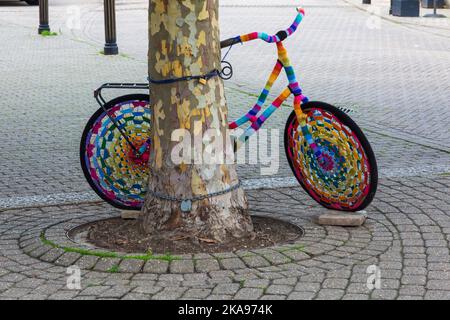 Bomba a filo colorato, bomba filo crochet crochet bici contro l'albero a Weymouth, Dorset UK nel mese di ottobre Foto Stock