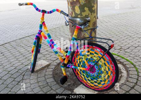 Bomba a filo colorato, bomba filo crochet crochet bici contro l'albero a Weymouth, Dorset UK nel mese di ottobre Foto Stock