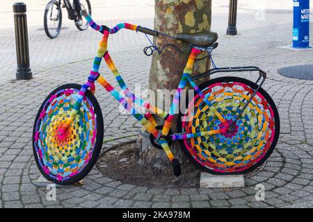 Bomba a filo colorato, bomba filo crochet crochet bici contro l'albero a Weymouth, Dorset UK nel mese di ottobre Foto Stock