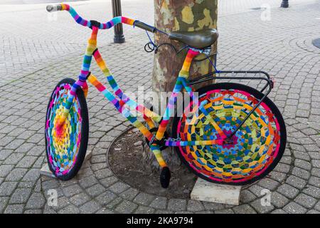 Bomba a filo colorato, bomba filo crochet crochet bici contro l'albero a Weymouth, Dorset UK nel mese di ottobre Foto Stock