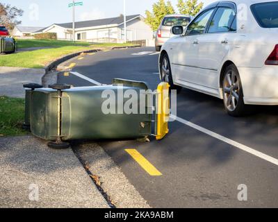 Vista dei cassonetti delle ruote dei rifiuti rovesciati dal forte vento che si posa a terra Foto Stock
