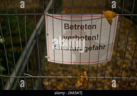 Cartello di avvertimento in tedesco in una recinzione con iscrizione: Tenere lontano per pericolo di collasso (tedesco 'Betreten verboten - Einsturzgefahr') Foto Stock