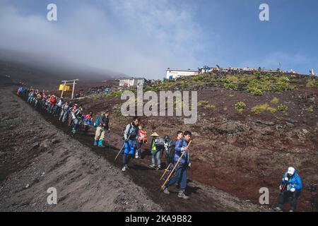 Un Giappone -turisti discendono dal Monte Fuji lungo il sentiero Yoshida. Foto Stock