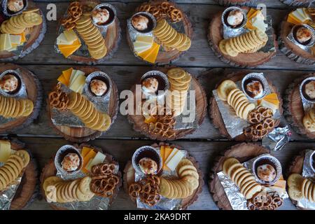 vista di deliziosi antipasti di nozze e battesimo pronti da servire con frutti di bosco, pretzel, cracker e formaggi diversi Foto Stock