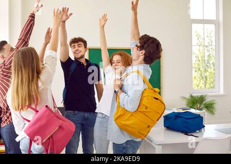 Gli studenti delle scuole superiori si alzano le mani in classe. Foto Stock