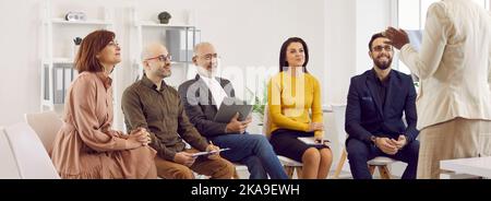 Soddisfatti vari imprenditori ascoltare attentamente la donna di affari che fa la presentazione per loro. Foto Stock
