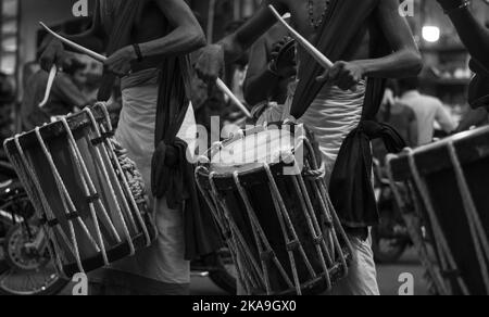 Un primo piano di un uomo indiano che suona il tradizionale Chenda tamburo percussioni durante un festival in Kerala Foto Stock