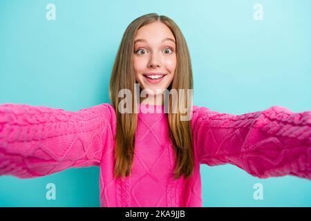 Selfie closeup foto di cute overjoyed pazzo ragazza indossare maglione rosa brillante prendere scatto eccitato popolare blogger isolato su sfondo di colore ciano Foto Stock