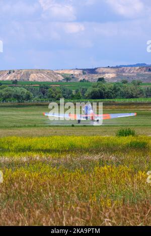 Aereo pronto per decollo su colline. In attesa su erba all'aperto in natura Foto Stock