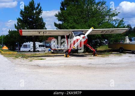 Aereo bianco parcheggiato in erba in una giornata di sole all'aperto Foto Stock