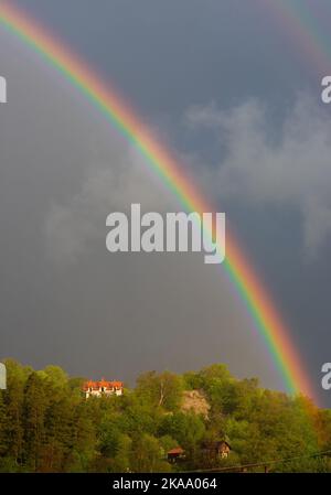 Parte di un arcobaleno su un cielo nuvoloso, una tempesta, una luce Foto Stock