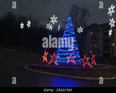Albero di Natale fatto di luci con stelle e fiocchi di neve. Atmosfera di Natale albero blu fiocchi di neve bianchi. Albero di Natale creativo. Foto Stock