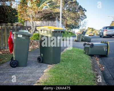 Vista dei cassonetti delle ruote dei rifiuti rovesciati dal forte vento che si posa a terra Foto Stock