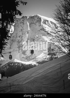 Un colpo in scala di grigi di funivie contro la montagna innevata del Monte Bianco in Europa Foto Stock