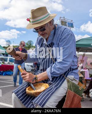 Poeta e autore Ian Bailey intagliando una ciotola di legno con uno scalpello. Foto Stock