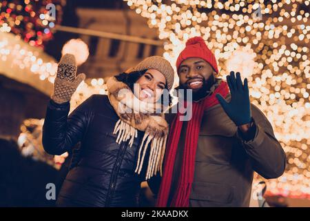 Ritratto di attraente coppia allegra moglie marito ondulazione ciao saluti visita Festal fiera riposo passatempo passeggiando città città all'aperto Foto Stock