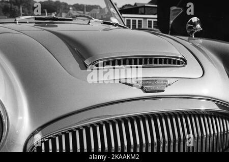 Il cappuccio di una Austin Healey vintage parcheggiata in un sacco a Rockport, Massachusetts. L'immagine è stata catturata su pellicola analogica in bianco e nero. Foto Stock