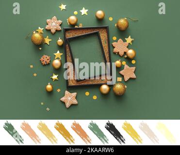 Composizione con cornice vuota, decorazioni natalizie e biscotti su sfondo verde. Diversi motivi di colore Foto Stock