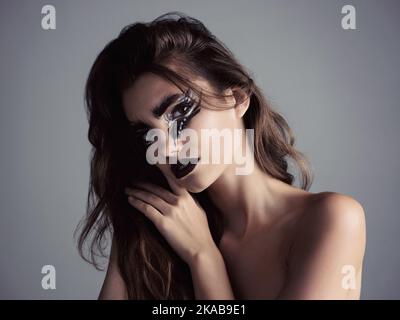 Lascia che il tuo trucco faccia la conversazione. Studio shot di una giovane donna attraente che indossa un trucco audace. Foto Stock
