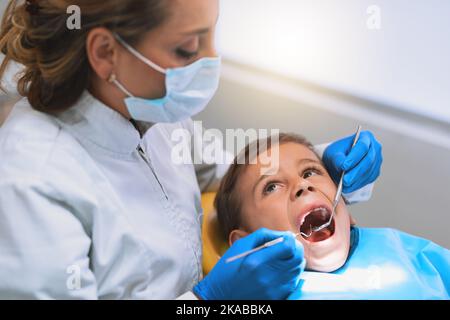 Niente dolore e niente stress. Un ragazzino sdraiato su una sedia da dentista mentre si ottiene un controllo dal dentista. Foto Stock