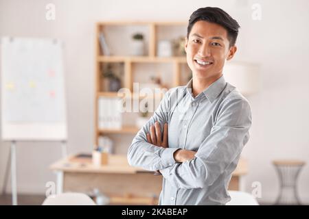 Leadership, ritratto e giovane uomo d'affari asiatico in piedi in uno spazio di lavoro creativo. Successo, startup e l'uomo con fiducia, felicità e motivazione dentro Foto Stock