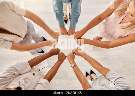 Lavoro di squadra, donne e cerchia di mani in pugno per il sostegno, l'unità e la collaborazione sul posto di lavoro. Motivazione, diversità e donne d'affari insieme con Foto Stock