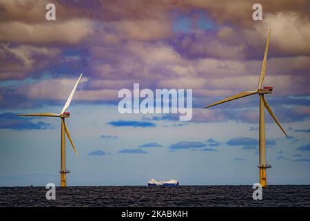 Foto del file datata 26/07/22 di una nave che passa per turbine eoliche presso Gwynt y Mor di RWE, mentre i dati chiave del settore dell'energia offshore si riuniranno ad Aberdeen mercoledì per discutere lo sviluppo di competenze verdi tra la forza lavoro per una giusta transizione dai combustibili fossili. Foto Stock