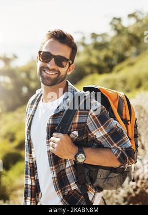 L'escursionismo mi fa sempre sorridere. Ritratto corto di un bel giovane che si fa trekking in montagna. Foto Stock