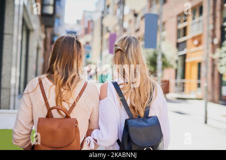 Vedere il mondo. Ripresa da dietro di due giovani fidanzate irriconoscibili che esplorano una città straniera. Foto Stock