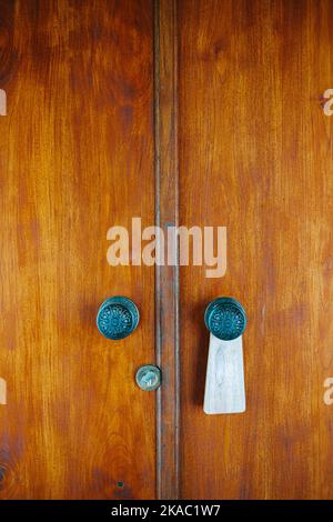 Tradizionale porta in legno con due maniglie in acciaio in un resort a Ubud, Bali, il 1st maggio 2022 Foto Stock