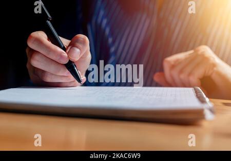 Primo piano mani di preparazione per le lezioni e lezioni accademiche presso la scrivania in legno con notebook e penna scrittura. Foto Stock