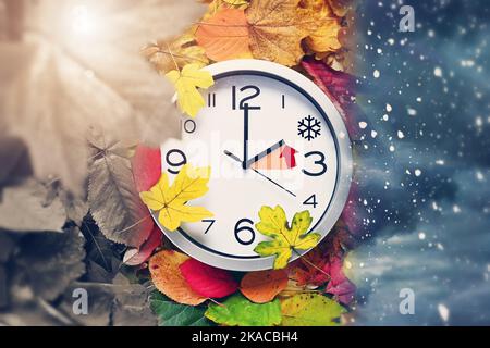 FOTOMONTAGE, Uhr auf Herbstblättern, Symbolfoto für die Rückstellung auf Winterzeit Foto Stock