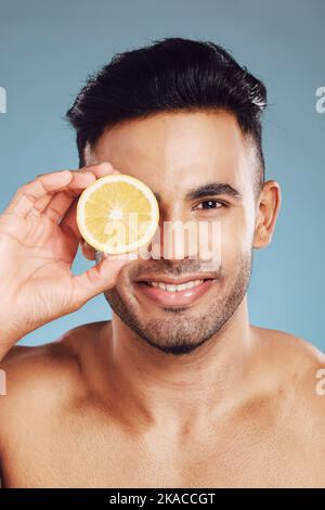 Cura della pelle, limone e uomo in studio per la bellezza, il benessere e la pulizia, detox e dieta su sfondo blu mockup. Volto, frutto e ritratto di messicano Foto Stock