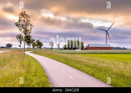 Terreni agricoli moderni con campi, mulini a vento e fienili nel paesaggio agricolo della provincia di Groningen, Paesi Bassi. Foto Stock