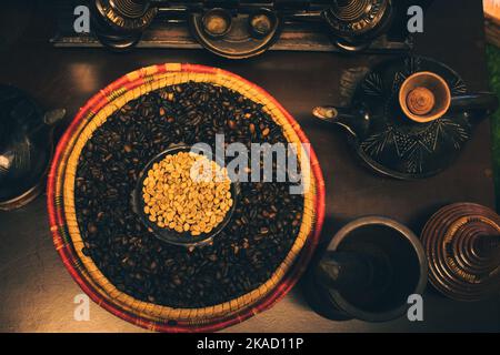 Dubai, Emirati Arabi Uniti - 12th ottobre 2022: Vista dall'alto chicchi di caffè arabico crudo e arrostito con macinacaffè e attrezzi per la preparazione del caffè. Tour del museo del caffè a Dubai Foto Stock