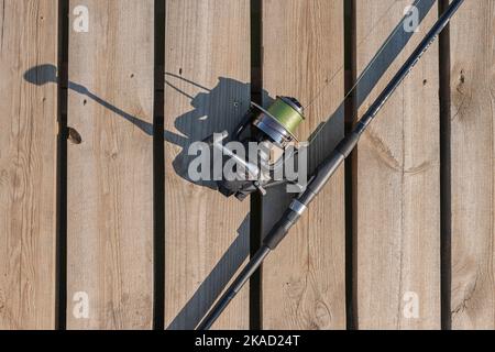 Canna da pesca o pescatore giacente su superficie di legno, vista dall'alto. Foto Stock