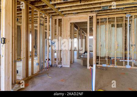 L'installazione di lana di fibra di vetro minerale tra travi da utilizzare nella costruzione di pareti è destinata a fornire isolamento termico e acustico Foto Stock