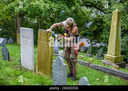 Plymouth, Massachusetts, USA - 12 settembre 2022: Un uomo lavora per pulire le lapidi sulla collina di sepoltura. Foto Stock