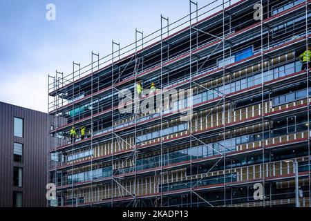 Reykjavik, Islanda - 31 marzo 2022: Edificio in costruzione nel centro di Reykjavik. Lavoratori in giubbotti gialli sul ponteggio. Foto Stock