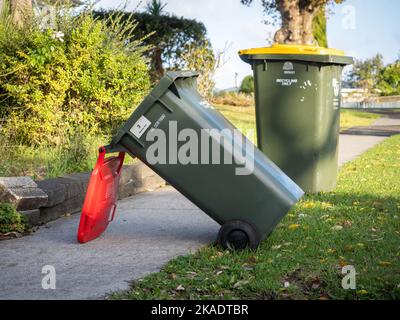 Vista dei cassonetti delle ruote dei rifiuti rovesciati dal forte vento che si posa a terra Foto Stock