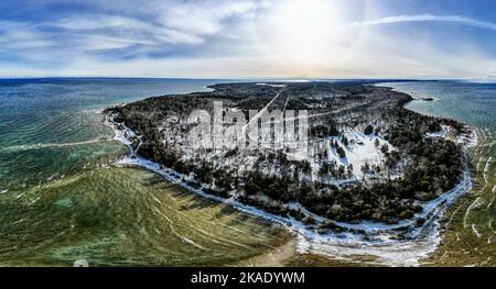 Una vista mozzafiato dall'alto di un'isola coperta di neve circondata dall'acqua Foto Stock