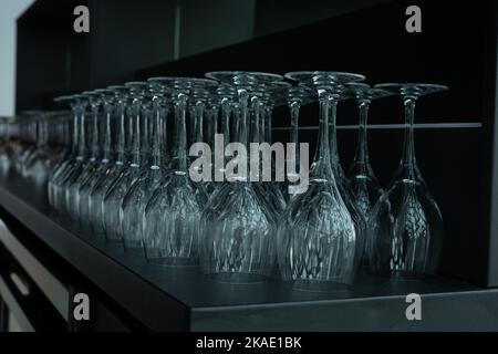 Primo piano di bicchieri da vino vuoti in fila sul tavolo del bar. Foto Stock