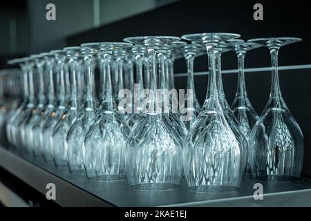 Primo piano di bicchieri da vino vuoti in fila sul tavolo del bar. Foto Stock