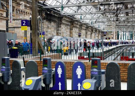 Una grande folla di persone che si affrettano fuori dal binario dopo essere arrivati alla stazione centrale di Glasgow, Scozia, su un treno Avanti West Coast. Foto Stock