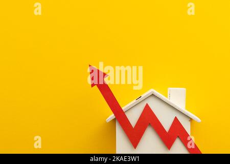 Aumento del costo della vita. Aumento dei tassi di inflazione ipotecari. Casa con una freccia rossa Foto Stock