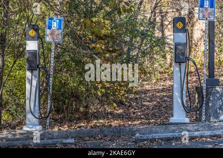 Due stazioni di ricarica per veicoli elettrici con segnaletica accanto al solo parcheggio per i veicoli elettrici da ricaricare in un parco all'aperto Foto Stock